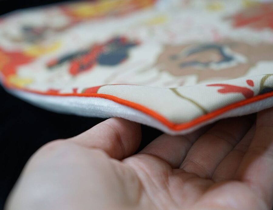 DEPLUSBELLE vous propose une housse de coussin unique en velours blanc cassé et néoprène imprimé avec passepoil orange!